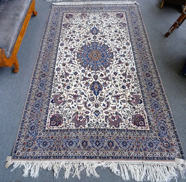 An Isfahan carpet, Persian, the ivory field with a bold pale indigo rosette medallion, a corner palmette in the pink spandrel all with intricate flora
