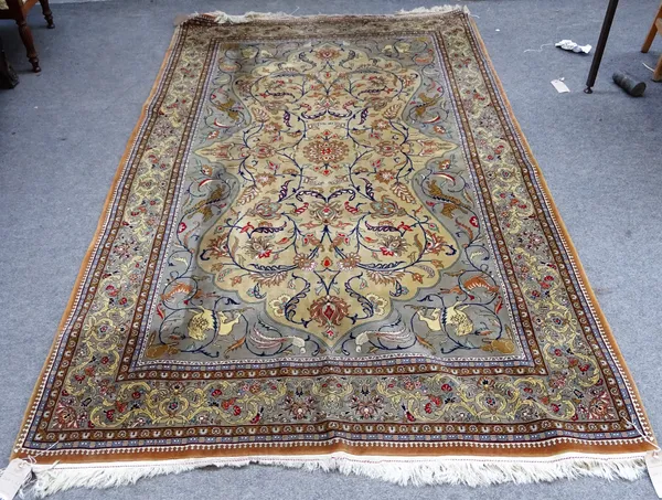 A Ghom rug, Persian, the beige field with a small central rosette, floral sprays, grey spandrels with hunting lions and tigers, a grey floral bouquet