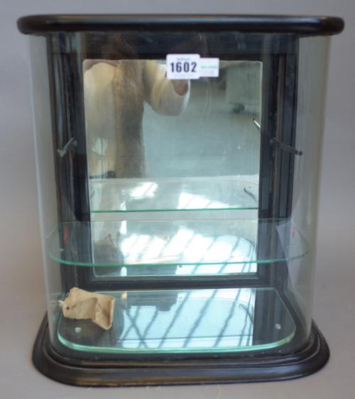 A Victorian ebonised and mahogany table top display cabinet with bow glazed front, enclosing a pair of adjustable shelves and mirrored door, 34cm wide