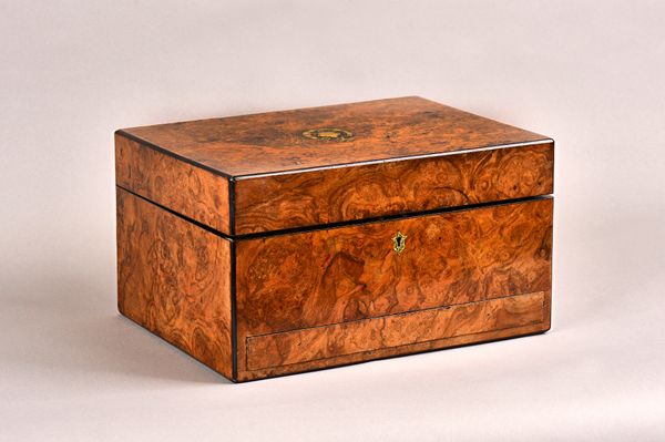 A Victorian figured walnut toilet box, the hinged lid enclosing a fitted interior and sprung drawer, 31cm wide x 17cm high x 23cm deep. Illustrated.