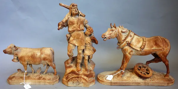 Three 19th century Black Forest figure groups depicting a cart horse, 35cm wide x 27cm high, a dairy cow, 24cm wide x 18cm high and a huntsman and son