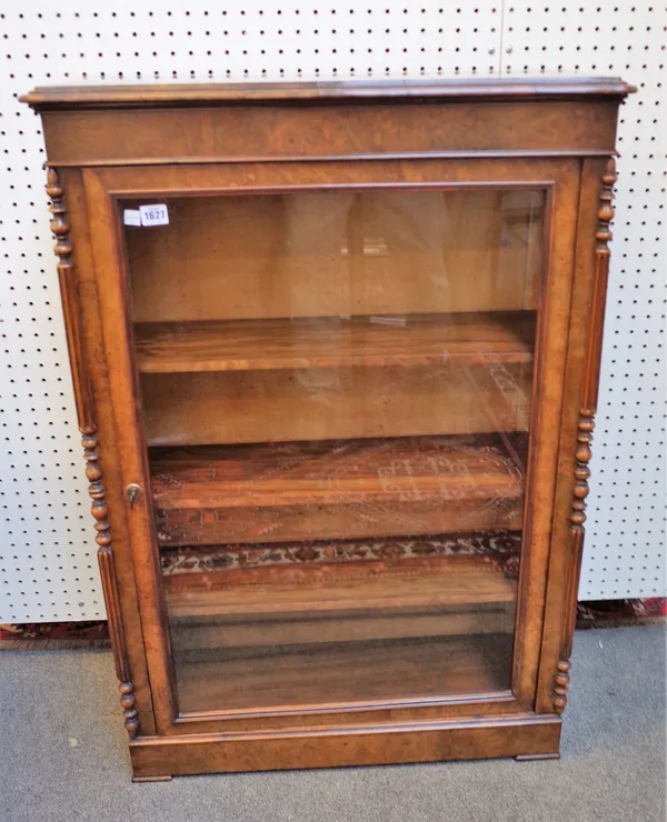 A Victorian figured walnut side cabinet, the serpentine top over single glazed door flanked by split turned and fluted columns, 72cm wide x 102cm high