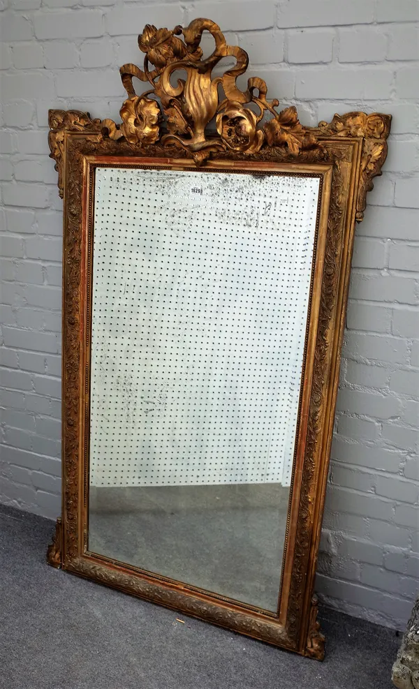 A 19th century gilt framed rectangular wall mirror, with ribbon tied floral spray crest and outstepped corners about the bevelled mirror plate, 95cm w