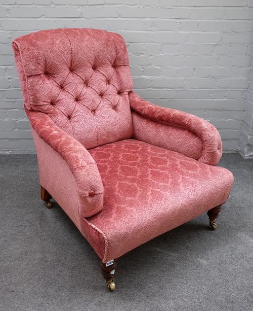 A mid Victorian easy armchair with button back and over stuffed arms on turned supports, the back leg is stamped 2702, 75cm wide x 84cm high.