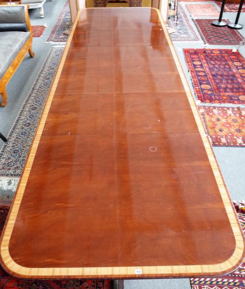 Possibly Arthur Brett, a George III style satinwood banded mahogany triple pillar extending dining table on ten downswept supports, to include two ext