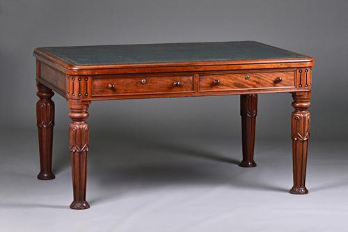 A William IV mahogany centre writing table with four opposing frieze drawers, on lappet carved tapering fluted supports, 138cm wide x 75cm high x 91cm