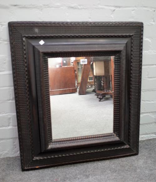 An 18th century Dutch wall mirror with ebonised wriggle work walnut cushion frame, 67cm wide x 75cm high.