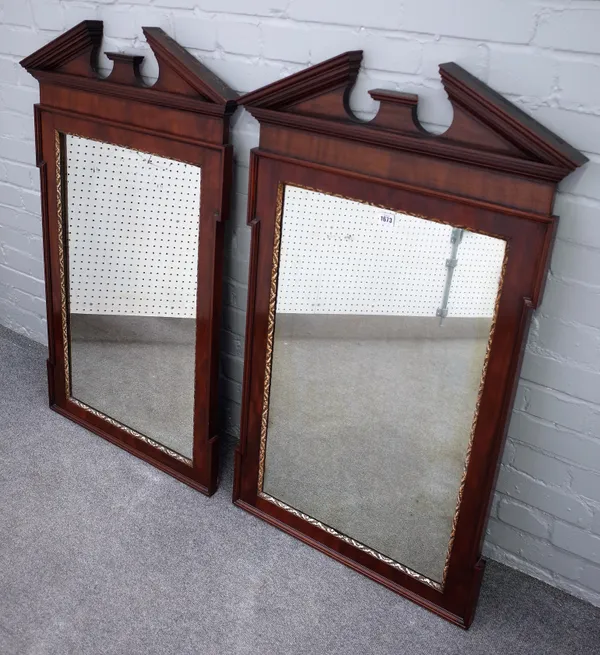A pair of George II style parcel gilt mahogany pier glasses, each with broken architectural cornice above in-stepped rectangular frames, 67cm wide x 1