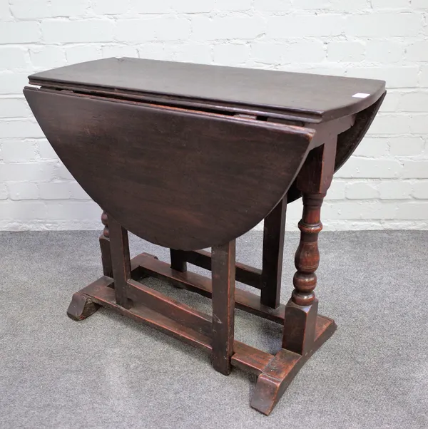 A 17th century oak gate-leg table, the oval top on baluster turned supports, 36cm across x 97cm across open x 77cm deep x 66cm high.