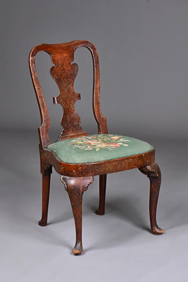 A George I burr elm side chair with scroll carved vase splat and bow seat resting on pad feet, 56cm wide x 94cm high. Illustrated.