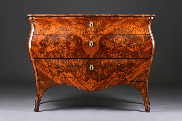 An 18th century and later inlaid walnut commode, the serpentine top over a bombe three drawer base on splayed supports, 130cm wide x 90cm high x 59cm