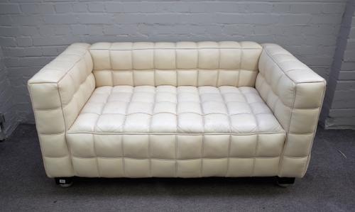 A 20th century cream leather square back sofa with piped cube pattern upholstery on ebonised bracket feet, 150cm wide x 72cm high x 80cm deep.