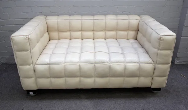 A 20th century cream leather square back sofa with piped cube pattern upholstery on ebonised bracket feet, 150cm wide x 72cm high x 80cm deep.