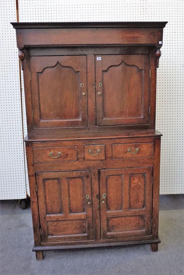 A mid-18th century oak court cupboard, the canopy top over a pair of shaped panel doors, three drawers and a further pair of doors on stile feet, 104c