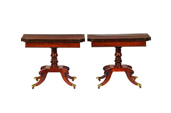 A pair of late George III rosewood banded mahogany card tables, each with break D-front foldover tops, on turned column and four ebonised bullseye mou