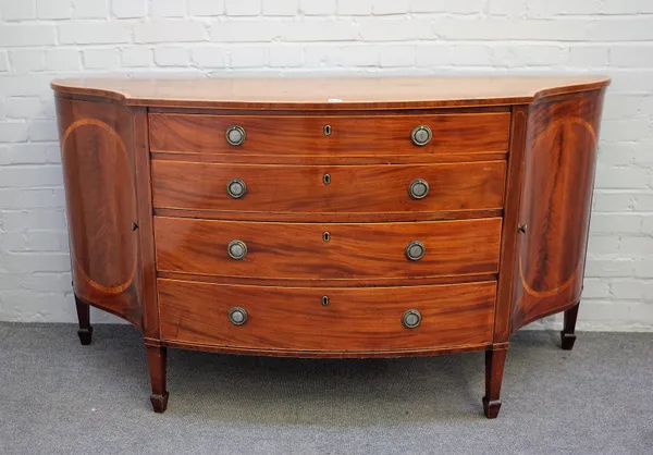 A George III inlaid mahogany commode, the serpentine top over four long graduated drawers, flanked by cupboards on tapering square supports, 168cm wid