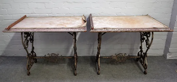 A pair of rectangular side tables, each on early 20th century wrought iron trestle type bases, 85cm wide x 65cm high x 61cm deep.