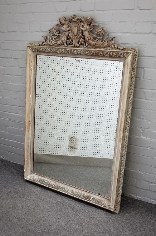 A 19th century later grey painted rectangular wall mirror, the cartouche crest with flanking winged cherubs, 100cm wide x 152cm high.