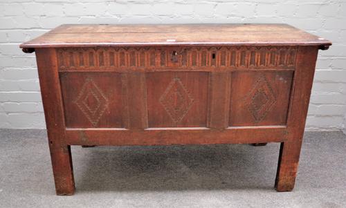 A 17th century oak coffer, the twin plank top over triple panel front on high stile feet, 122cm wide x 73cm high x 48cm deep.