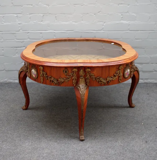 An 18th century style French gilt metal and ceramic mounted kingwood coffee/bijouterie table with shaped glazed hinged top on four cabriole supports,