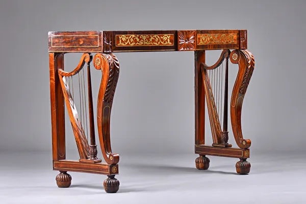 An early 19th century Irish brass inlaid mahogany and rosewood console table, the serpentine top on a pair of harp supports on melon carved feet, top