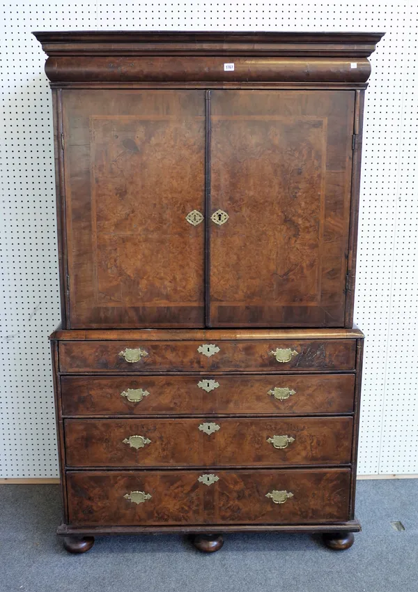 A George I featherbanded figured walnut secretaire cabinet on stand, the pair of doors enclosing a fitted interior above secretaire drawer and three f