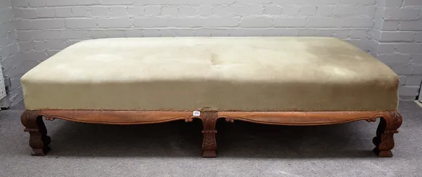 A late 19th century walnut framed rectangular footstool with shaped frieze on six scale carved block supports, 187cm wide x 45cm high x 87cm deep.