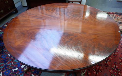 After Jupes, a George III style circular extending dining table on four baluster turned columns and downswept supports to include five additional peri