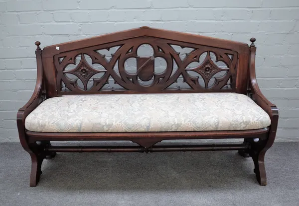 A Victorian walnut Gothic Revival hall bench, the pointed arch back with pierced decoration on X-frame supports, 137cm wide x 85cm high.