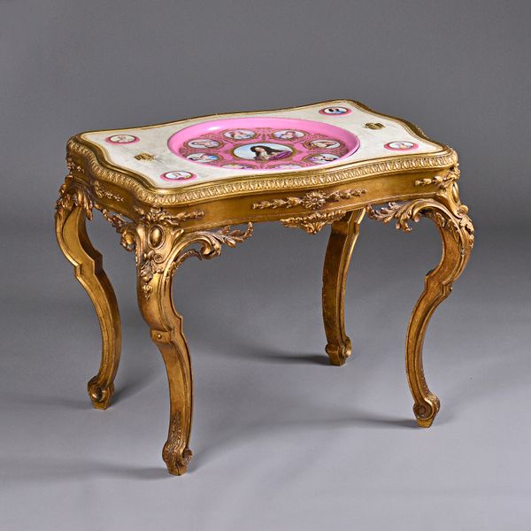 A 19th century French gilt salon table, the serpentine rectangular top inset with Sevres style ceramic plaques, depicting Louis XIV and his mistrresse