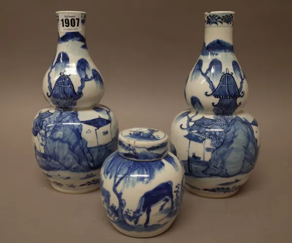 A pair of Chinese blue and white double gourd vases, circa 1900, each painted with a river landscape with figures leading a buffalo across a bridge, f