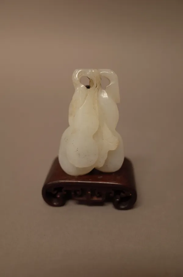 A Chinese white jade carving of gourds, 6cm.high, wood stand, (2).
