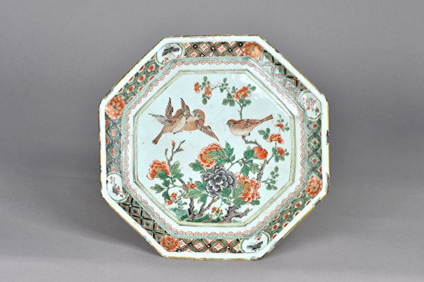 A Chinese famille-verte octagonal stand, Kangxi, painted with three birds amongst branches of flowering peony, the elaborate border reserved with pane