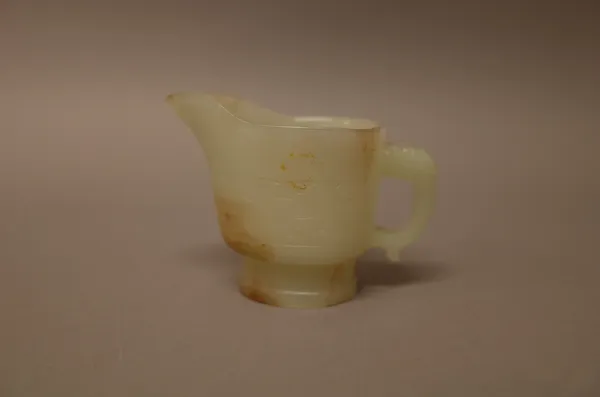 A Chinese pale celadon jade libation cup, carved with a band of archaic scrolls, 7cm. high.