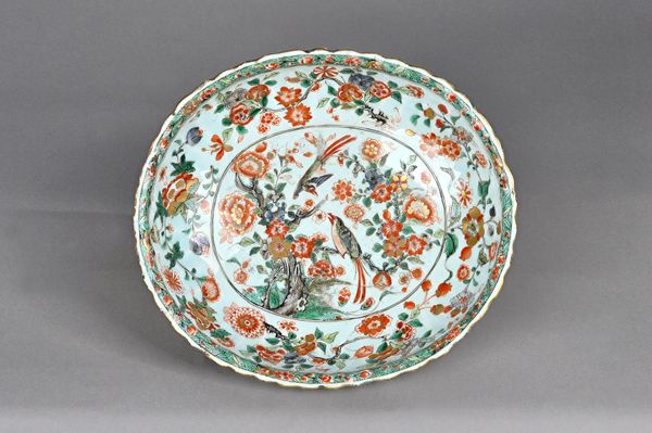 A Chinese famille-verte oval fluted bowl, Kangxi, the interior painted with two birds amongst flowering branches inside a border of scattered flowers,