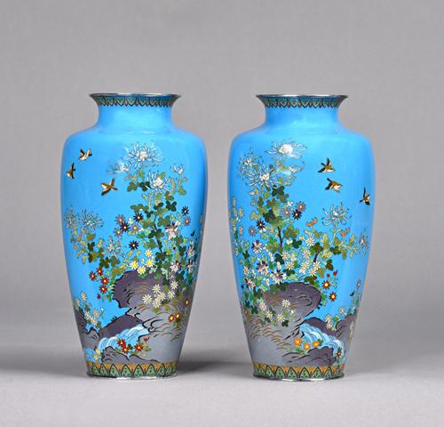 A pair of Japanese cloisonné vases, Ando studio, Meiji period, each worked with birds in flight above flowering shrubs issuing from a rock against a b