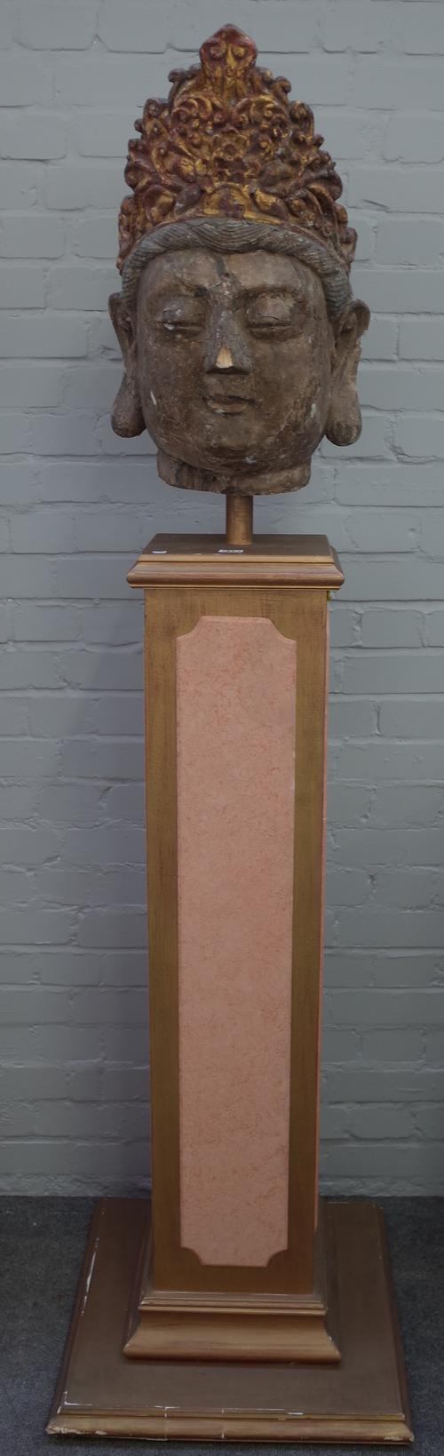 A large Chinese painted and  parcel giltwood carved head of Guanyin, Ming Dynasty, modelled with serene expression, her hair tied back back into a chi