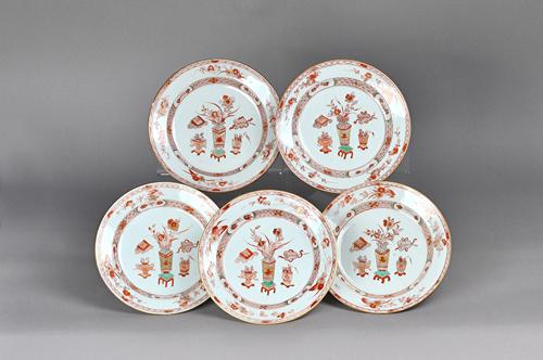 A set of seventeen Chinese export plates, Kangxi, each painted in iron-red, green and gilding, in the centre with Precious Objects, inside a border pa