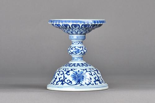 A pair of Chinese blue and white stands, probably 19th century, each domed base painted with lotus below a knopped stem and circular top,blue painted