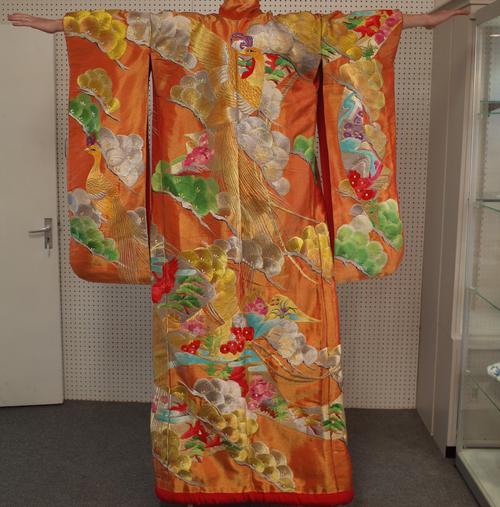 A Japanese embroidered wedding kimono, 20th century, brightly worked with pheasants amongst flowers against and orange and gold ground, 186cm. length.