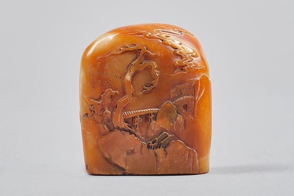 A Chinese brown soapstone boulder seal, Qing Dynasty, carved on one side with two figures crossing a bridge, the reverse with a bridge and buildings a