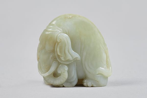 A small Chinese pale celadon jade figure of an elephant, Qing Dynasty, carved standing four-square, 4.5cm. high. Illustrated. Provenance; From a disti