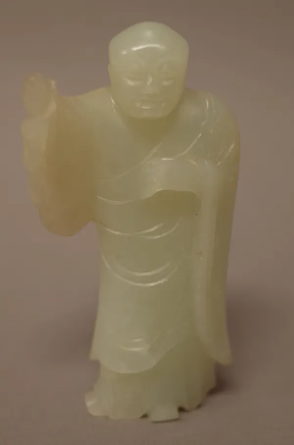 A Chinese pale celadon jade figure of a man, standing in long robes with right arm raised, 7.75cm. high, wood stand.Provenance; From a distinguished U