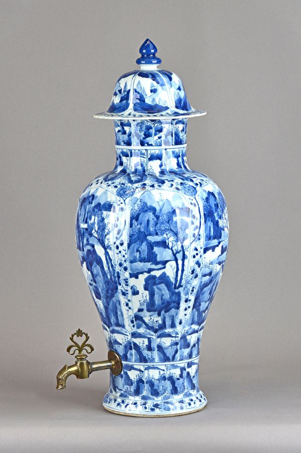 A tall Chinese blue and white baluster vase and cover, Kangxi, with moulded panels enclosing landscape scenes, later fitted metal spigot, (a.f), 58cm.