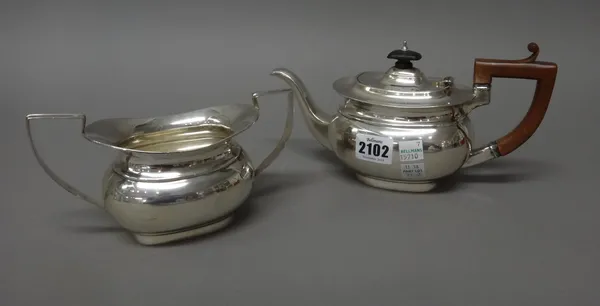 A silver teapot and a matching silver twin handled sugar bowl, each piece of compressed oval form, the teapot with associated composition fittings, Bi