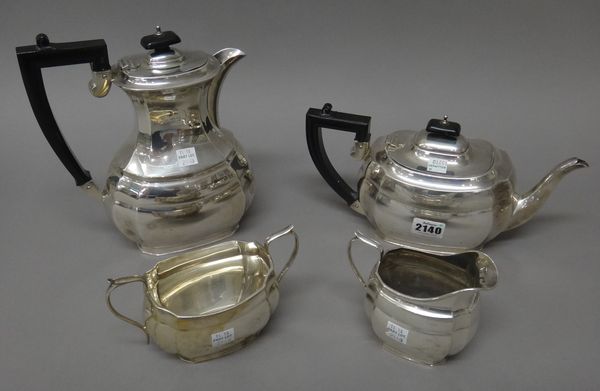 A silver four piece tea set, comprising; a teapot, a hot water jug, a twin handled sugar bowl and a milk jug, each piece of panelled oval form, the tw