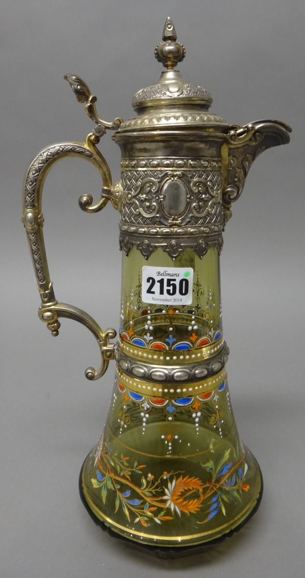 A German late 19th century silver mounted glass claret jug, the glass body with varicoloured enamel decoraton in the manner of Heisler, height 34cm. I