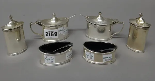 A group of silver condiments, comprising; two mustard pots with blue glass liners, two salts with blue glass liners, two pepperettes, each piece of ov