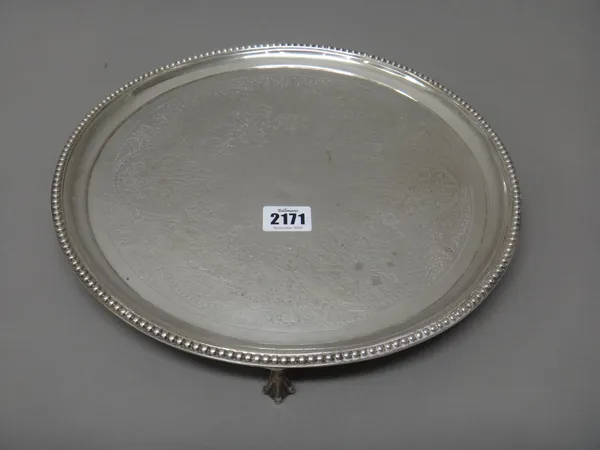 A Victorian silver salver, of circular form, with engraved decoration within a beaded rim, raised on three ball and claw feet, London 1874, diameter 3