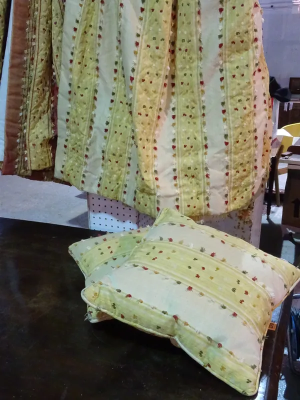 A pair of lined and interlined gold striped curtains with spot decoration, each 133cm wide x 135cm fall and two matching square cushions, 36cm wide, (